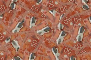 50 Canadian dollars bills lies in big pile. Rich life conceptual background photo