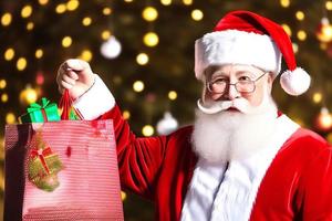 Cheerful Santa Claus is placing gift boxes. Merry Christmas and happy holidays. photo