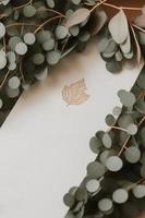 Mockup for a letter or wedding invitation with branches and leaves. Natural light and shade coverage. photo