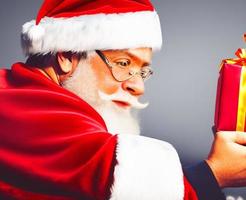 Cheerful Santa Claus is placing gift boxes. Merry Christmas and happy holidays. photo