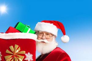 Cheerful Santa Claus is placing gift boxes. Merry Christmas and happy holidays. photo