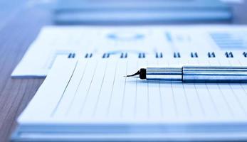 Close up sliver ballpoint pen with notebook on table in meeting photo