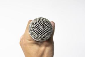 Hand holding a microphone isolated on white background photo