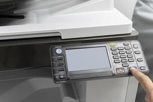 Man pressing a button to start a copy machine photo