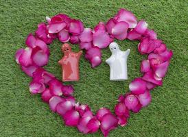 Top view pink rose petals arranged in a heart shape with mock up couple hugging in heart. Valentine day concept. photo