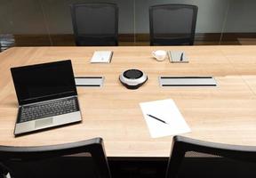 pantalla de portátil en blanco y portátil en la mesa en la sala de reuniones. concepto de lluvia de ideas foto