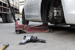 White cars change wheels using a lifting jack. photo