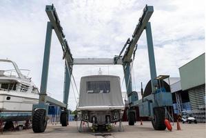 Back view of the boat in shipyard, being lifted by industrial crane. photo