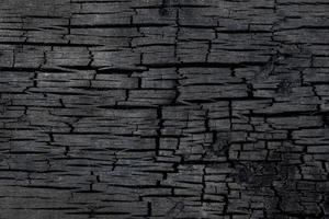 Burned wood charcoal texture background. Black burnt wood surface photo