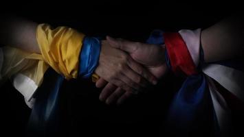 Russian flag and Ukraine flag in hands showing symbol of struggle war photo