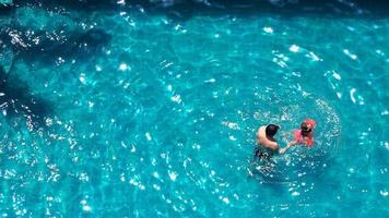 Swimming pool and father and daughter and playing together and happiness moment and top view. photo