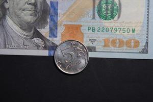 5 rublos rusos en un billete de 100 dólares. el concepto de la crisis económica. tasa de guerra dólar y rublo foto