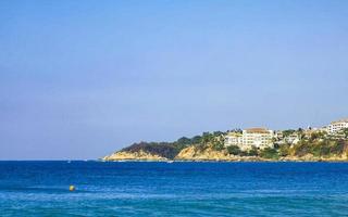 Beach sand blue water huge surfer waves Puerto Escondido Mexico. photo