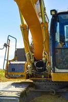 Yellow large excavator on the dike and forest in Germany. photo