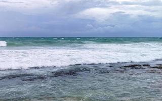 el hombre está en la playa durante el huracán y disfruta de México. foto