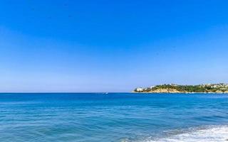 Beach sand blue water huge surfer waves Puerto Escondido Mexico. photo