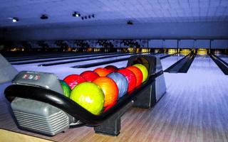 los adolescentes y los niños juegan a los bolos y lanzan una bola de bolos en alemania. foto