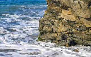 Big surfer waves and rocks at beach Puerto Escondido Mexico. photo