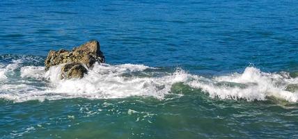 Big surfer waves and rocks at beach Puerto Escondido Mexico. photo