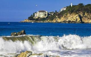 Big surfer waves and rocks at beach Puerto Escondido Mexico. photo