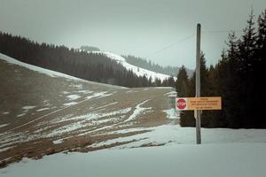 Warning sign for tourists in mountains landscape photo