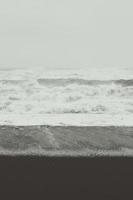 Foamy waves on black beach monochrome landscape photo