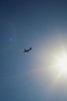 Airplane flying across blue sky landscape photo