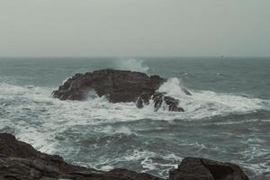 Old cliff and waves in sea landscape photo