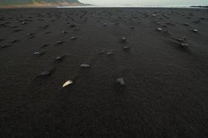 Close up black sand with basalt stones concept photo