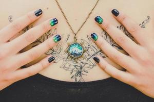 Close up woman with craft pendant and manicure concept photo