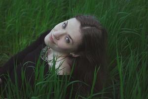 Close up smirking woman in tall grass staring directly into camera portrait picture photo