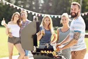 Friends having barbecue party in backyard photo