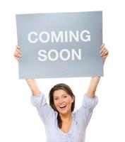 Girl holding a Coming soon sign photo