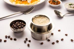 café de filtro del sur de la India servido en una taza tradicional de latón o acero inoxidable foto