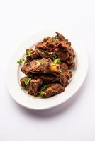 Sukha mutton or chicken, dry spicy Murgh or goat meat served in a plate or bowl photo