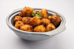 papas bombay asadas caseras. papas pequeñas fritas en sartén o aloo con semillas de jeera y cilantro en un tazón foto