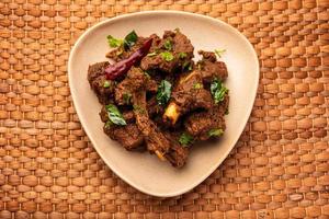 Sukha mutton or chicken, dry spicy Murgh or goat meat served in a plate or bowl photo