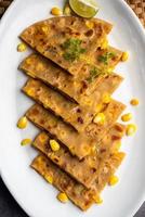 Sweet corn stuffed paratha or parotha served in a plate, Indian flatbread recipe made filling makai photo