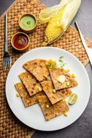 Sweet corn stuffed paratha or parotha served in a plate, Indian flatbread recipe made filling makai photo