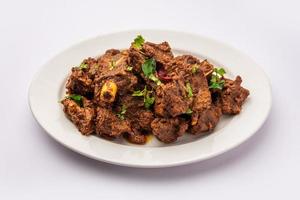 Sukha mutton or chicken, dry spicy Murgh or goat meat served in a plate or bowl photo