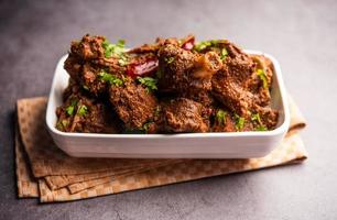 Sukha mutton or chicken, dry spicy Murgh or goat meat served in a plate or bowl photo