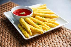 Crispy fried baby corn pakoda, pakora  or Baby corn fritters served with ketchup, Indian food photo