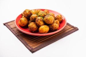 Homemade Roasted Bombay potatoes. Pan fried little baby potatoes or aloo with jeera seeds and coriander in bowl photo