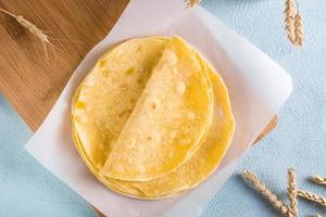 Homemade mexican corn tortillas on a wooden board on the table. Top view photo