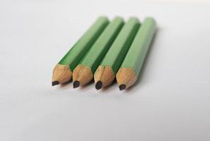 four green pencils on paper sheet photo