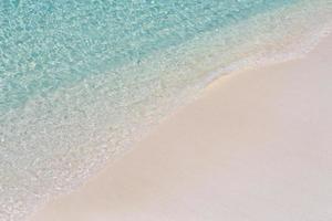 Soft beautiful ocean wave on sandy beach background. Tropical beach nature, carefree and inspiration concept photo