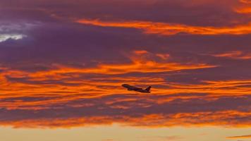 avión frente a nubes rojas que brillan intensamente en la noche roja foto