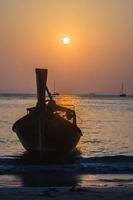 Sunset over the sea with boat silhouette photo