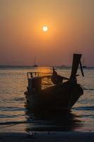 Sunset over the sea with boat silhouette photo