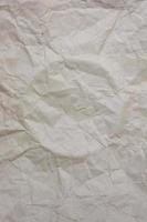Vertical background from old crumpled paper, with a circle squeezed out in the middle. photo
